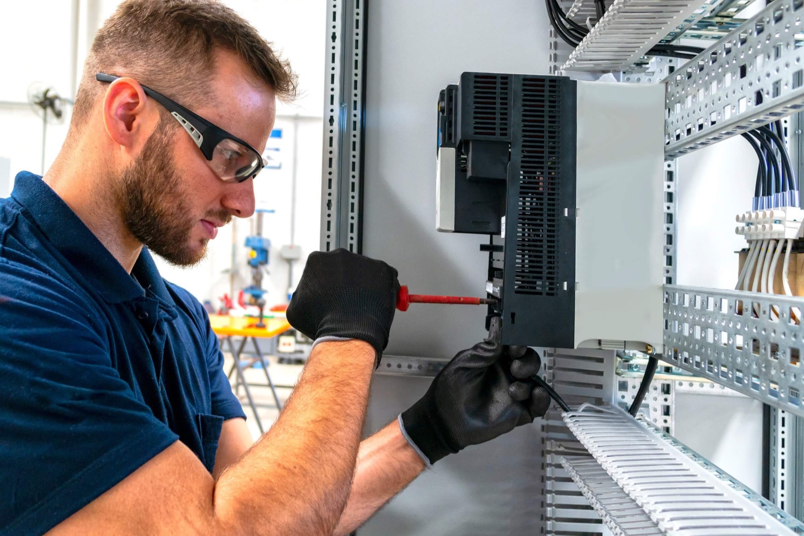 FalconTech electrician installing equipment in an electrical control panel